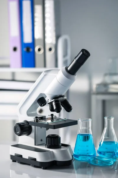 Різні Лабораторні Скляні Посуд Світло Блакитною Рідиною Мікроскопом Столі — стокове фото