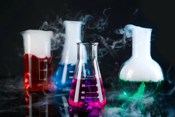 Лабораторний Скляний Посуд Різнокольоровими Рідинами Парою Чорному Тлі Хімічна Реакція — стокове фото
