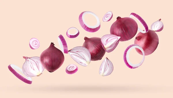 Whole Cut Fresh Red Onions Falling Light Coral Background — Stock Photo, Image