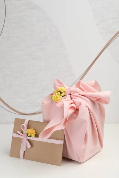 Técnica Furoshiki Presente Embalado Tecido Rosa Cartão Flores Mesa Branca — Fotografia de Stock