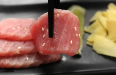 Siyah tabaktan lezzetli sashimi (taze çiğ ton balığı) alıyoruz, yakın plan.