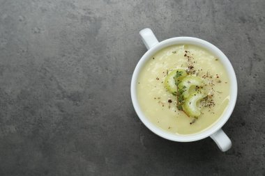 Bir kase lezzetli kereviz çorbası, gri masa, üst manzara. Metin için boşluk