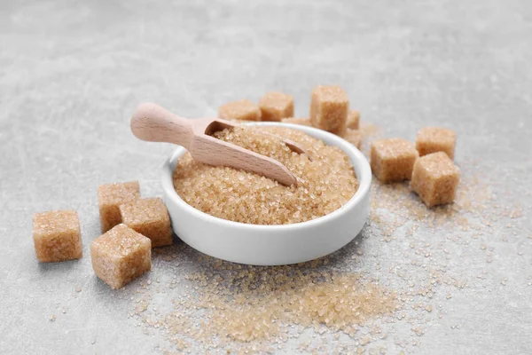 Different types of brown sugar on grey table