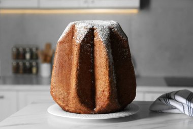 Lezzetli Pandoro keki. Mutfaktaki beyaz masanın üzerine pudra şekerle süslenmiş. Geleneksel İtalyan pastası