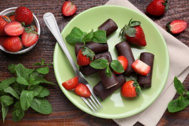 Lezzetli kremalı aperatifler taze çilekler ve ahşap masa üzerinde nane şekeri.