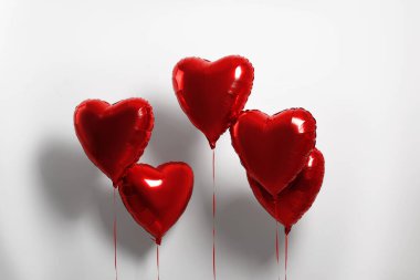Many red heart shaped balloons on white background