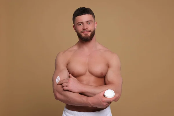 Knappe Man Het Aanbrengen Van Body Cream Zijn Arm Lichtbruine — Stockfoto