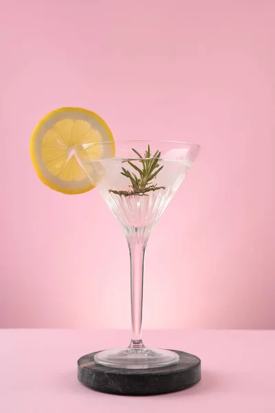Martini Sklenice Koktejl Plátkem Citronu Rozmarýnem Stojanu Proti Růžovému Pozadí — Stock fotografie