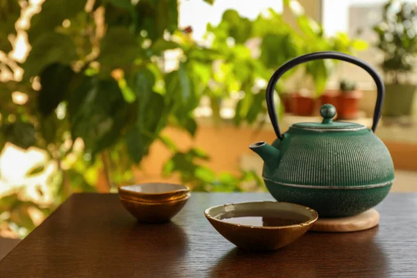 茶壶和一杯新鲜煮好的茶放在室内的木制桌子上 文字的空间 传统仪式 — 图库照片