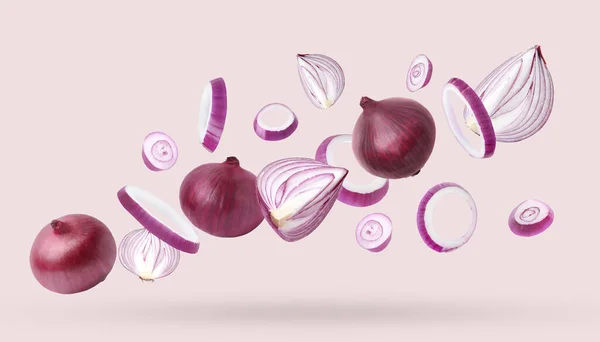 Whole Cut Fresh Red Onions Falling Light Pink Background — Stock Photo, Image