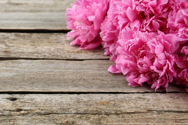 Stock image Beautiful pink peonies on wooden table, closeup. Space for text