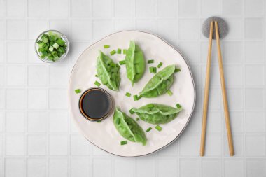 Lezzetli yeşil hamur köfteleri (gyozas) beyaz fayanslı masa üzerinde servis edilir, düz yatar