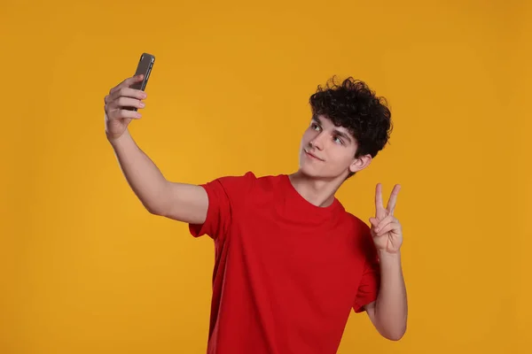 Teenager Macht Selfie Und Zeigt Friedensgeste Auf Orangefarbenem Hintergrund — Stockfoto