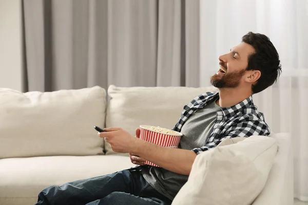 Śmiejący Się Mężczyzna Ogląda Telewizję Popcornem Kanapie Domu — Zdjęcie stockowe