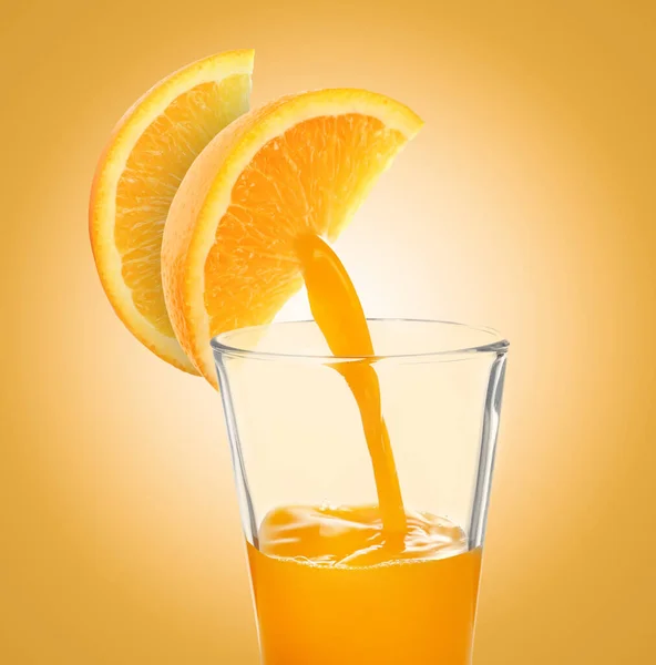 オレンジを新鮮に 黄金の背景にオレンジの柑橘類のスライスからガラスに注ぐジュース — ストック写真