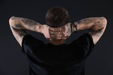 Siyah arka planda poz veren yakışıklı hippi.