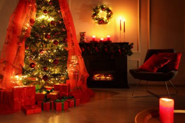 Beautifully wrapped gift boxes under Christmas tree near fireplace in living room clipart