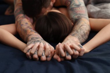 Passionate couple having sex on bed, focus on hands clipart