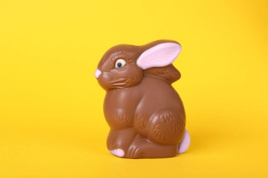 Sarı arka planda çikolatalı tavşan. Paskalya kutlaması