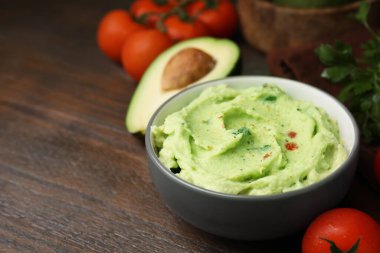 Bir kase lezzetli guacamole ve ahşap masada malzemeler. Metin için boşluk