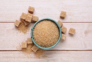 Rafine ve granüllü kahverengi şeker beyaz ahşap masa, düz yatıyordu