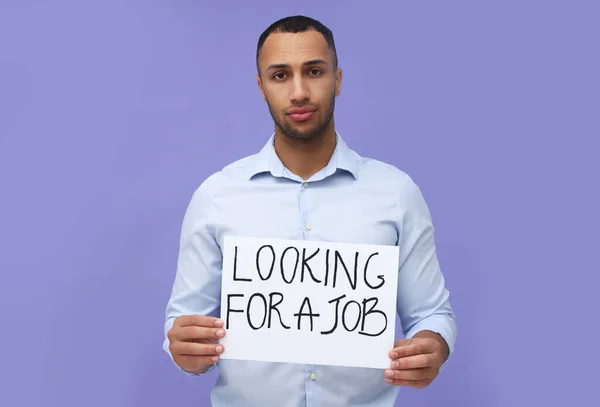 年轻的失业男子举着标语 上面写着 寻找一份背景为紫色的工作 — 图库照片