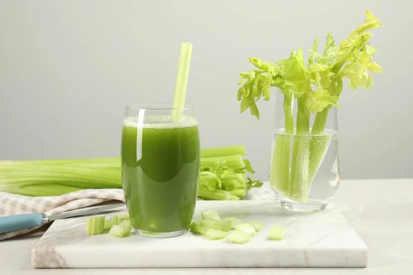 薄緑色のテーブルの上にセロリジュースと新鮮な野菜のガラス — ストック写真
