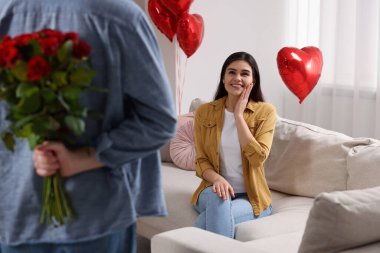 Sevgili karısı için bir buket kırmızı gül saklayan adam, yakın plan. Sevgililer Günü kutlaması