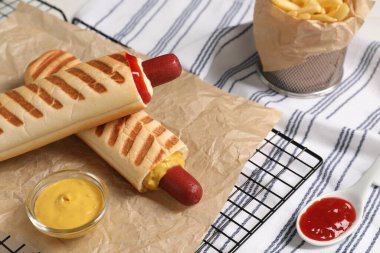 Lezzetli Fransız sosislileri, kızarmış patatesler ve soslar masada.