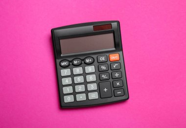 Pembe arka planda hesap makinesi, üst manzara. Ofis ekipmanı