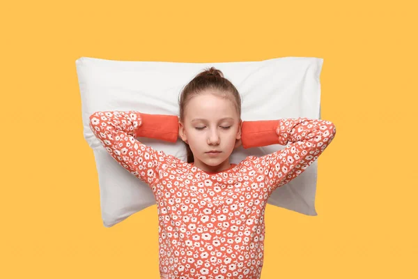 オレンジ色の背景に枕を持つ眠そうな女の子 不眠症の問題 — ストック写真