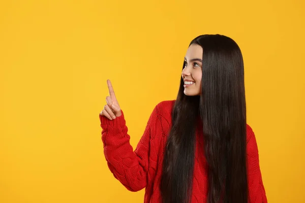 Nastolatka Wskazująca Coś Żółtym Tle Miejsce Tekst — Zdjęcie stockowe