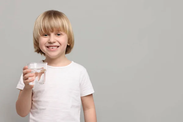 Glad Liten Pojke Som Håller Glas Sötvatten Ljusgrå Bakgrund Plats — Stockfoto