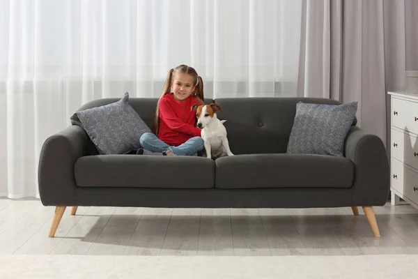 可爱的女孩和她的狗在沙发上在家里 可爱的宠物 — 图库照片