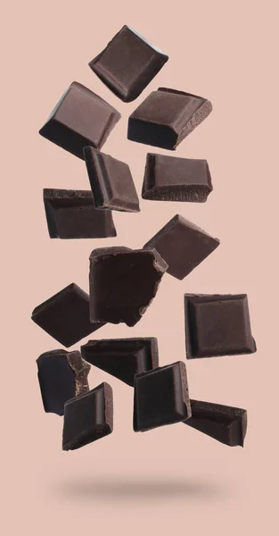 Kousky Čokolády Bar Padající Béžové Pozadí — Stock fotografie
