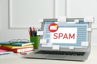 E- posta yazılımında çöp posta uyarısı. Ofis masasında dizüstü bilgisayardan çıkan zarf çizimleri
