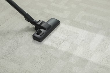 Elektrikli süpürgeyle halı süpürmek, mesaj için yer açmak. Kirli yüzeyde temiz iz