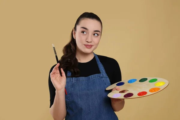 带着米色背景绘画工具的女人 年轻的艺术家 — 图库照片