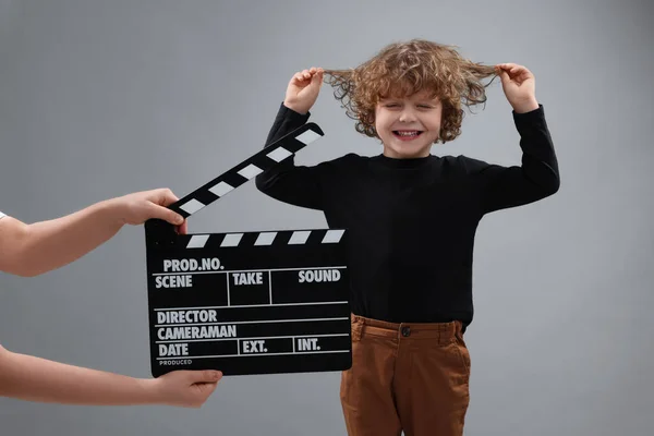 Glad Söt Pojke Utför Medan Andra Assistent Kamera Hålla Clapperboard — Stockfoto