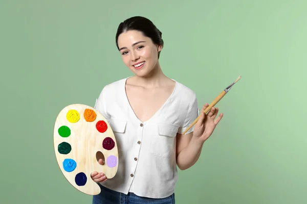 拥有淡绿色背景的绘画工具的女人 年轻的艺术家 — 图库照片