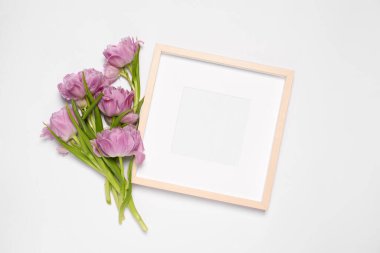Boş fotoğraf çerçevesi ve beyaz arka planda güzel lale çiçekleri. Tasarım için model