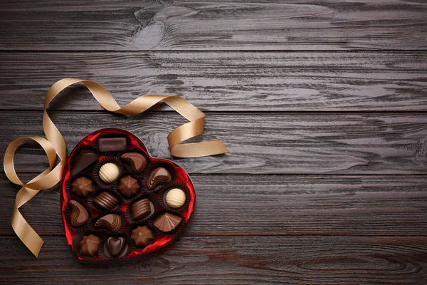心形盒子 有美味的巧克力糖果和带在木制桌子上 案文的篇幅 — 图库照片