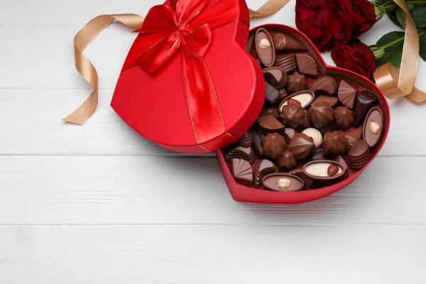 心形盒 上有美味的巧克力糖果 玫瑰和缎带 铺在白色木制桌子上 平铺在地板上 案文的篇幅 — 图库照片
