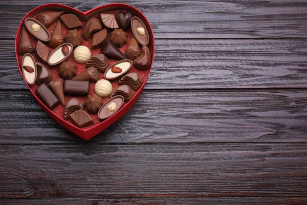 Hartvormige Doos Met Heerlijke Chocolade Snoepjes Houten Tafel Bovenaanzicht Ruimte — Stockfoto