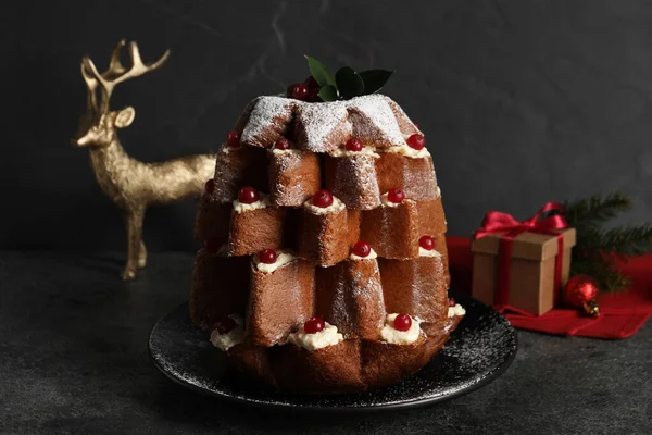 黒テーブルの上でお祝いの装飾の近くに粉砂糖とベリーとおいしいパンドラのクリスマスツリーケーキ — ストック写真