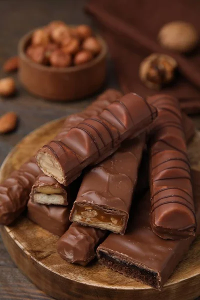 stock image Pieces of different tasty chocolate bars on wooden board, closeup