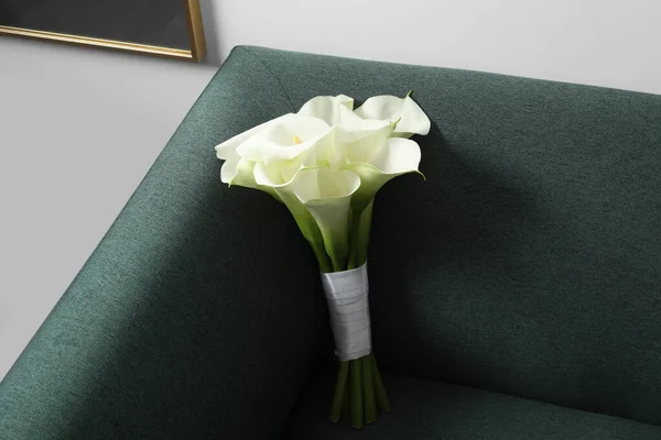 ソファの上にリボンで結ばれた美しいカラユリの花室内 — ストック写真