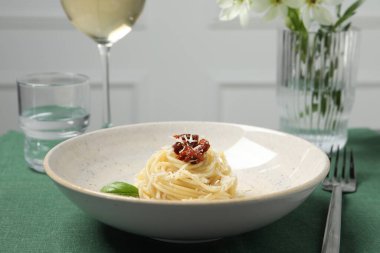 Masada servis edilen güneşte kurutulmuş domatesli ve parmesan peynirli leziz spagetti. Makarna yemeğinin enfes sunumu