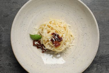 Lezzetli spagetti, güneşte kurutulmuş domates ve parmesan peyniri. Makarna yemeğinin enfes sunumu