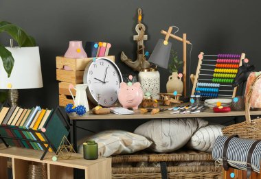 Gri duvarın yanında bir sürü farklı eşya var. Garaj satışı